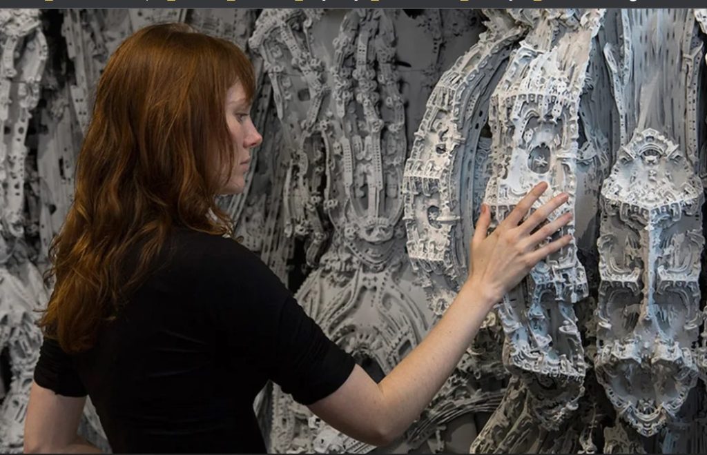 An artist standing near 3D-printed art