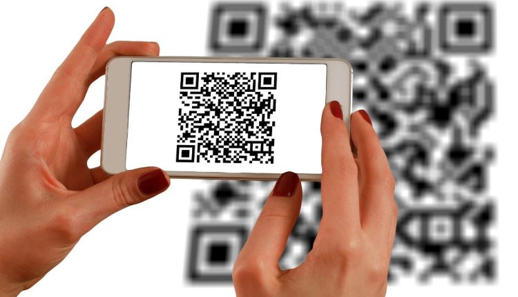 Hands holding a phone up to scan qr code