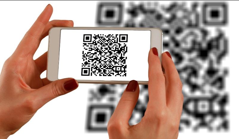 Hands holding a phone up to scan qr code