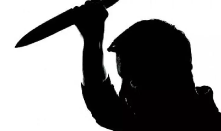 Image of a man lifting a knife up in a motion to stab